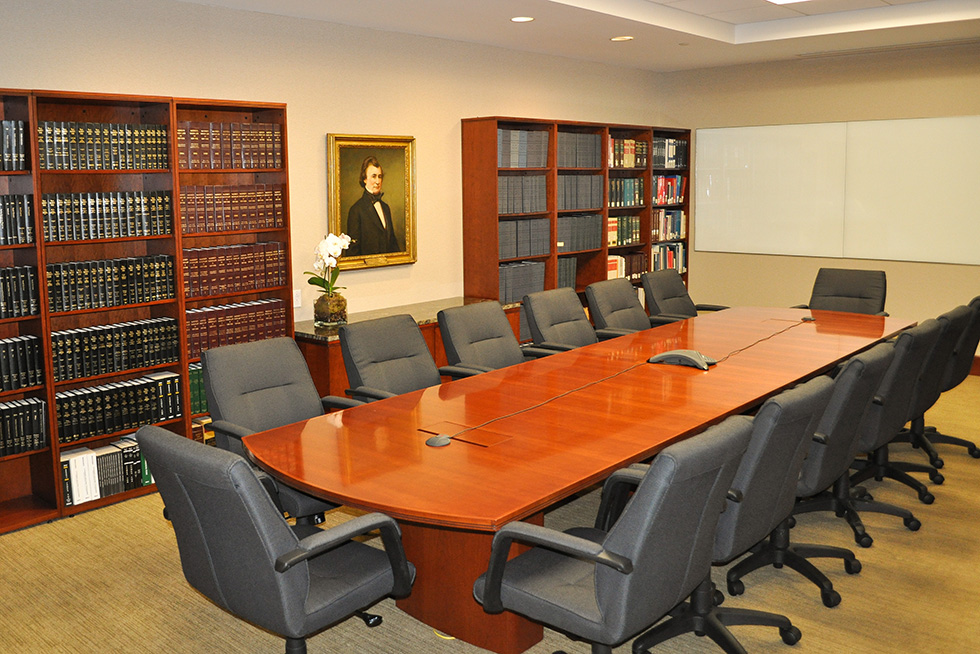 The library's custom wood bookshelves are well outfitted for research and provides an impressive backdrop for formal meetings at the conference table 
