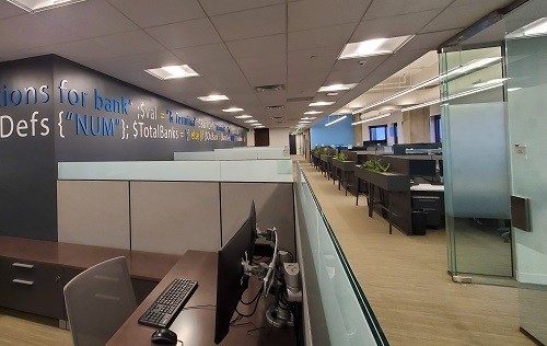 Open office area with low walled workstations adjacent to exterior windows