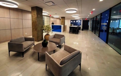  The multi-purpose reception area, outfitted in neutral earthy tones, includes informal seating and teaming areas as well as access to enclosed meeting rooms and large reconfigurable boardroom