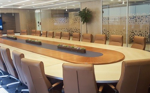 Racetrack style board room table comfortably accommodates thirty in modern high back chairs