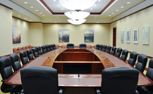 The traditional leather topped conference table, in the formal boardroom, incorporates modern technology including built-in video displays viewable from every seating position