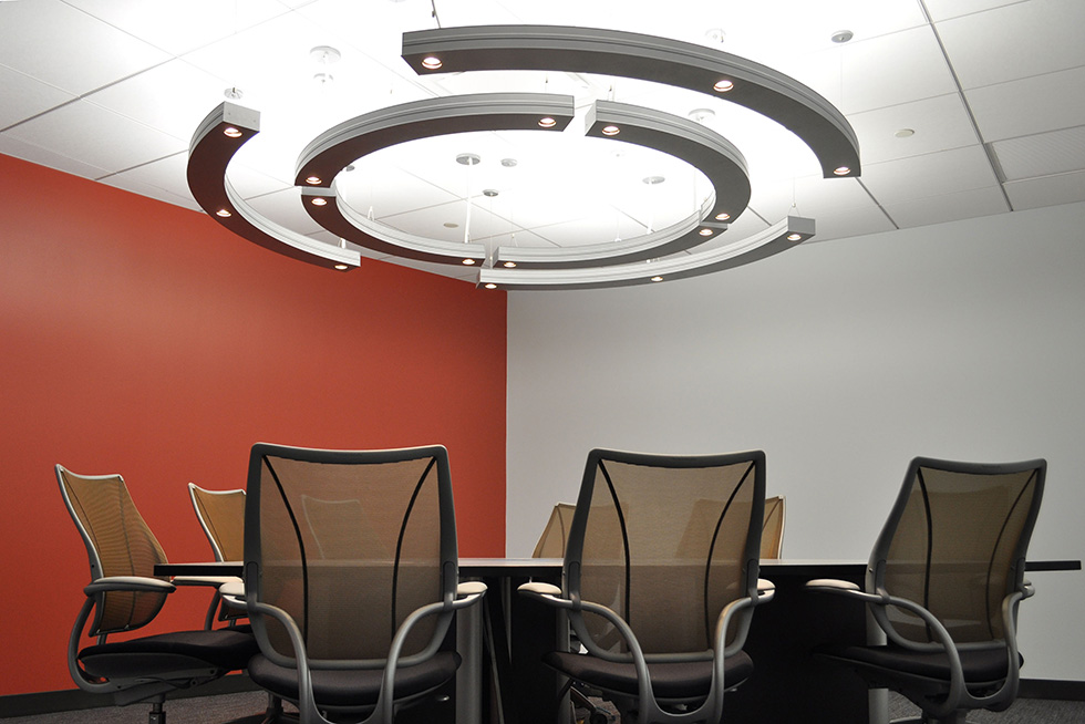 Teaming room with round table and curved LED fixture overhead